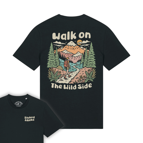 A black short-sleeve graphic T-shirt shown from the back, with a large illustrated mountain landscape print and the words “Walk on The Wild Side” in cream. A smaller inset at lower left shows the front chest print reading “Stoked & Stoked.