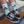 Person wearing 'Stoked' socks with mountain design and black Vans shoes on a wooden surface.